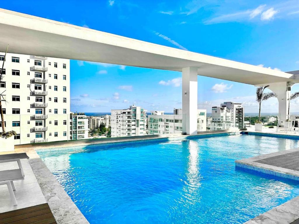 una piscina en la azotea de un edificio en Comfy Apt, Rooftop Lounge, Pool, en Ensanche Quisqueya