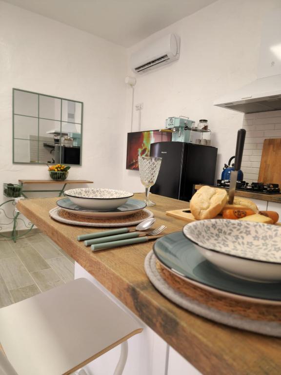 a kitchen with plates and bowls on a wooden table at La Herbolera Vv Apartamento in Teror