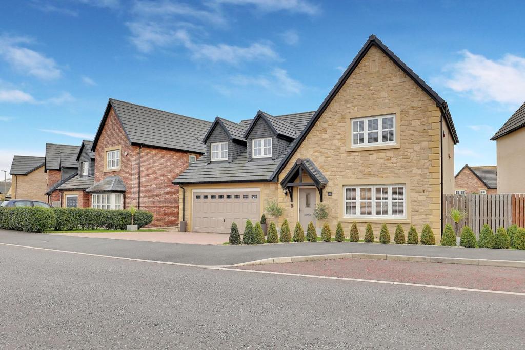 een groot bakstenen huis met een garage bij Sunrise View - North East Escapes in Long Houghton