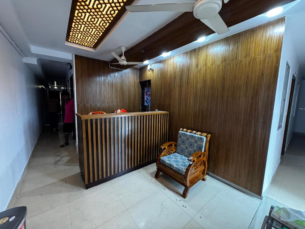 a chair in a room with a wooden wall at Hotel Tayef Zigatola in Dhaka