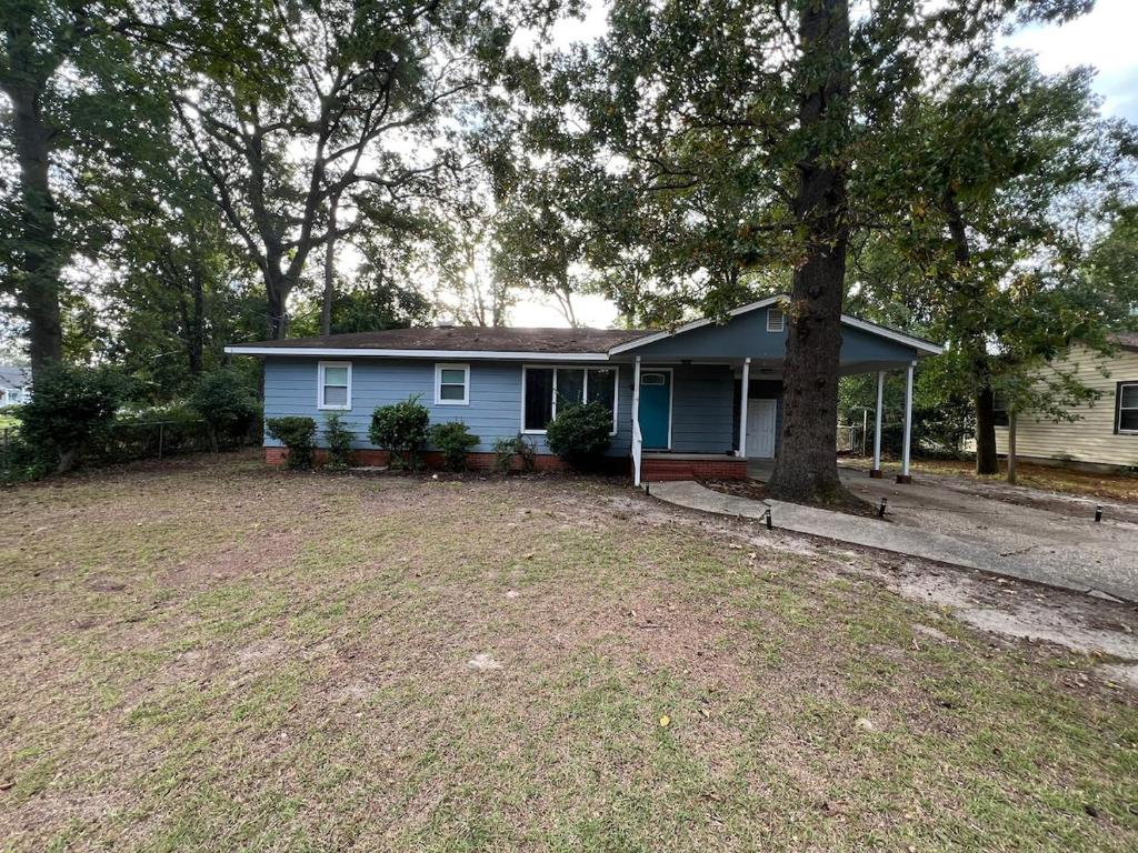a blue house with a tree in the yard at Minimalist-Modern Home with Keyless Entry and Parking in Fayetteville