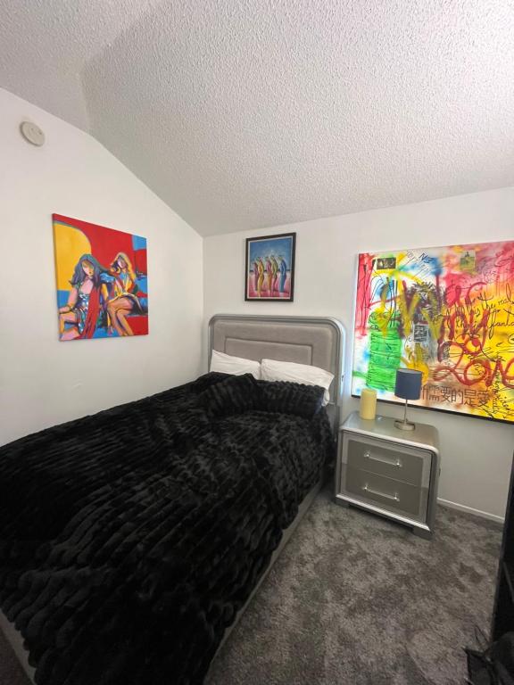 a bedroom with a bed and paintings on the wall at Charming room in artist studio and Gallery in Santa Clarita