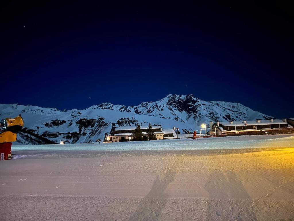 une montagne enneigée la nuit avec un bâtiment dans l'établissement Le Domaine du Lary, à Cadeilhan-Trachère