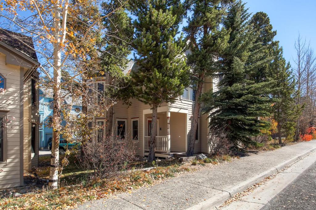 a white house with trees in front of a street at Victorian Gables E by Ski Country Resorts in Breckenridge