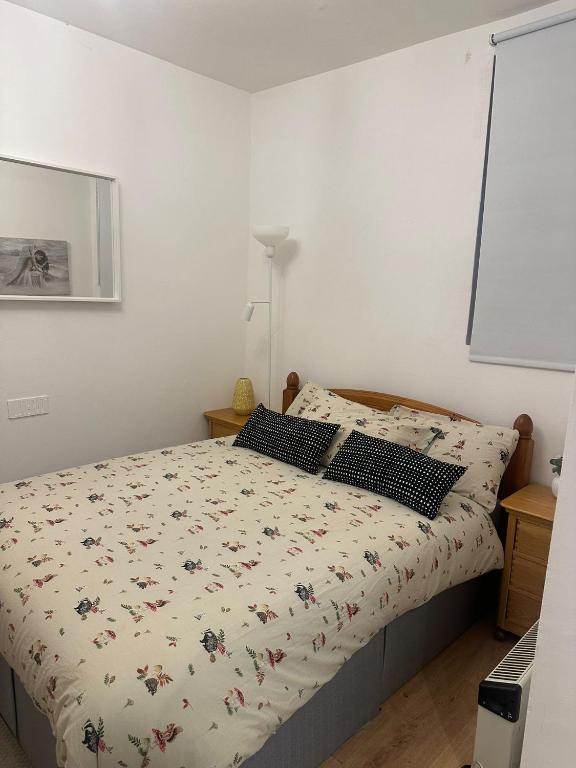 a bedroom with a bed with a floral bedspread at Comfy stay, Stockwell SW9 in London