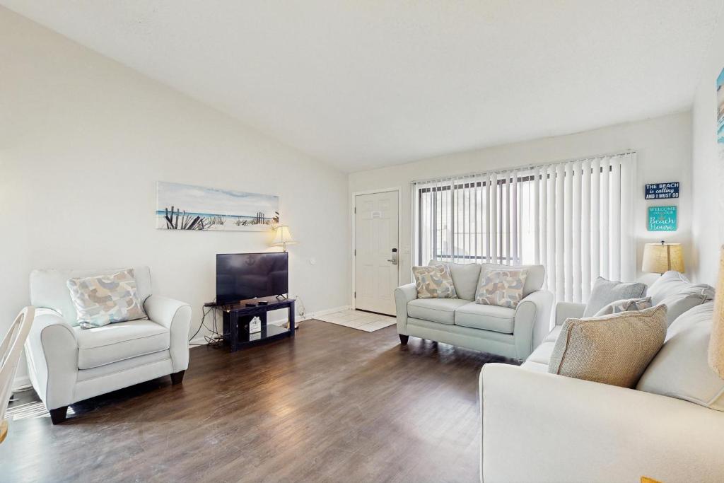 un soggiorno con mobili bianchi e TV a schermo piatto di Horizon South 23D a Panama City Beach