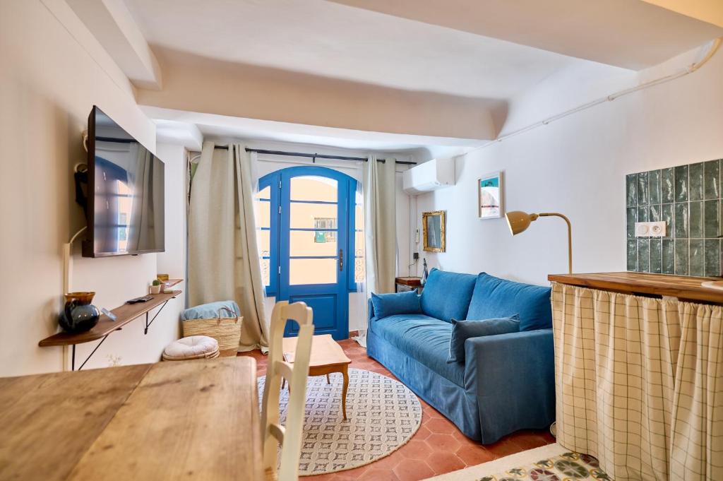 a living room with a blue couch and a table at Romantic getaway in Bormes in Bormes-les-Mimosas