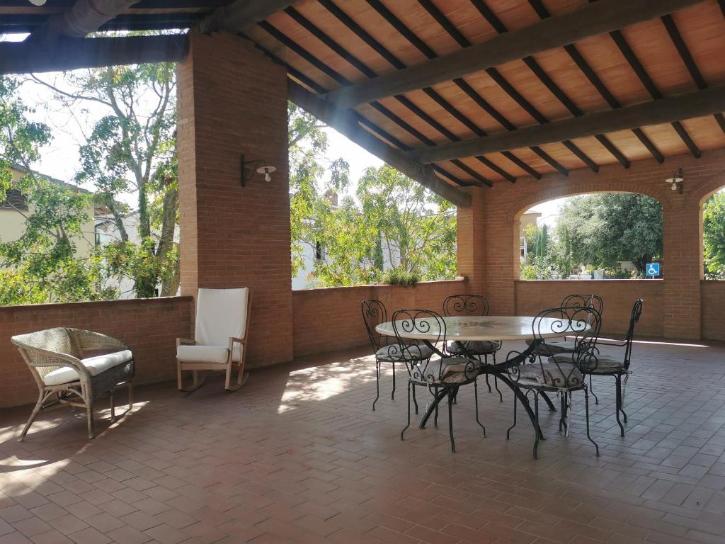a patio with a table and chairs and windows at La Terrazza di Maria in Pienza