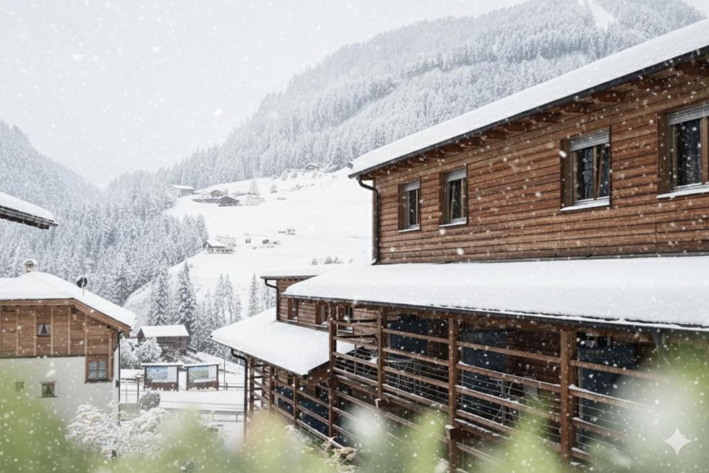 a building with snow on the roof of it at Alpstay - Smart Hotel Saslong in Santa Cristina in Val Gardena