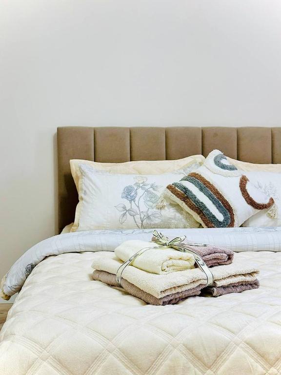 a bed with towels and pillows on it at K7 Family in Atyraū