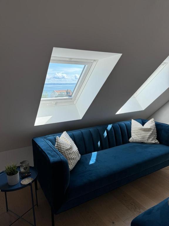 a blue couch in a room with a window at Tolle Wohnung mit Seeblick! in Rorschach
