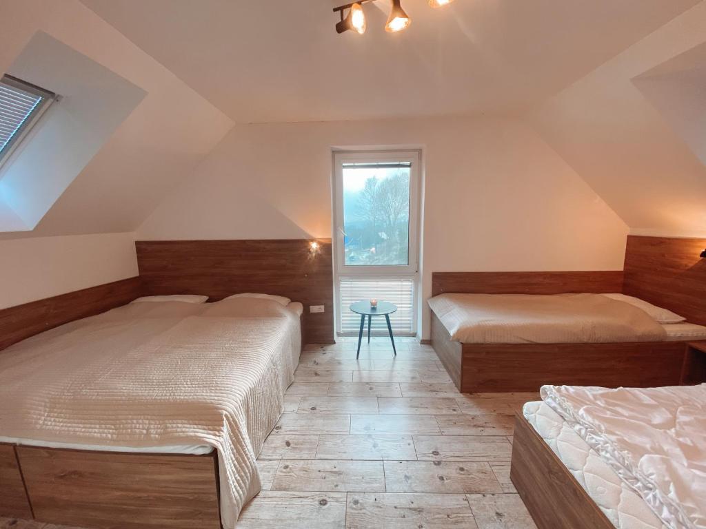 een slaapkamer met twee bedden en een raam bij Chalet Dolní Morava in Dolní Morava