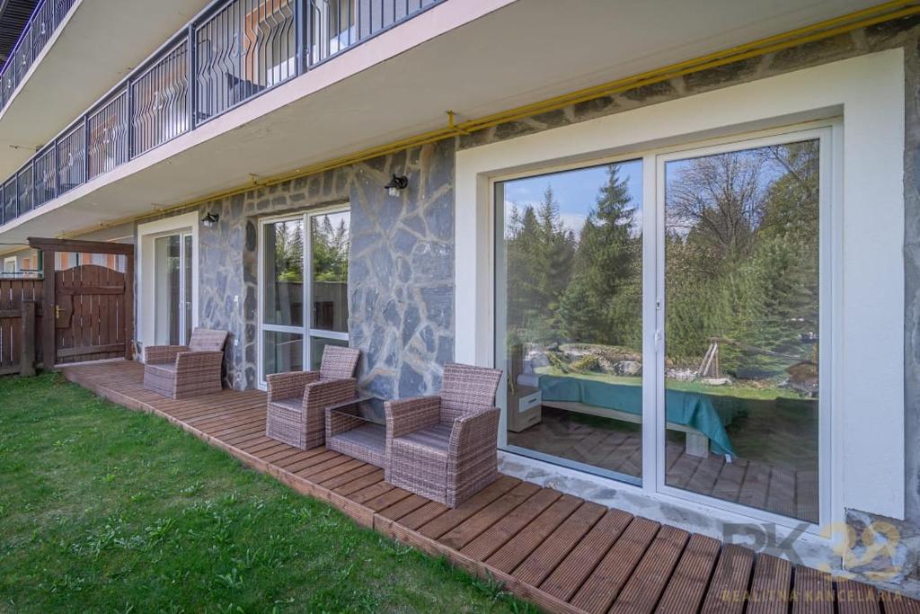 a patio with chairs and a table on a house at Apartmán Alex, Nezábudka in Tatranska Strba