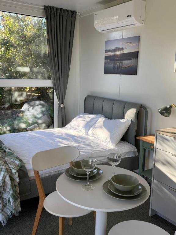 a bedroom with a bed and a table with plates on it at Poilsio namelis in Kretingalė