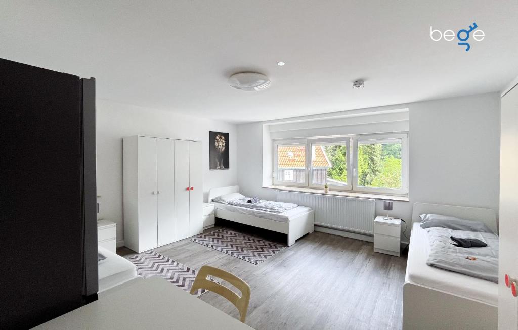 Una habitación blanca con una cama y una ventana. en BEGE APARTMENTS PrimeWork, en Hagen