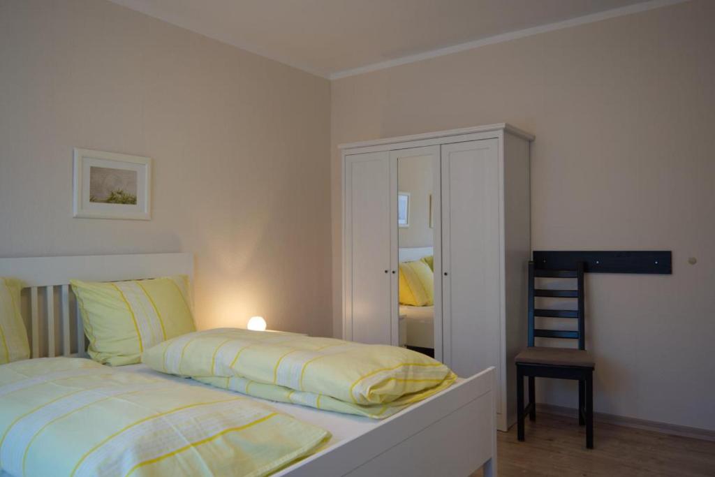 a bedroom with a bed with yellow sheets and a mirror at Inselblume 05 - Große Ferienwohnung in Landkirchen mit Hund in Landkirchen