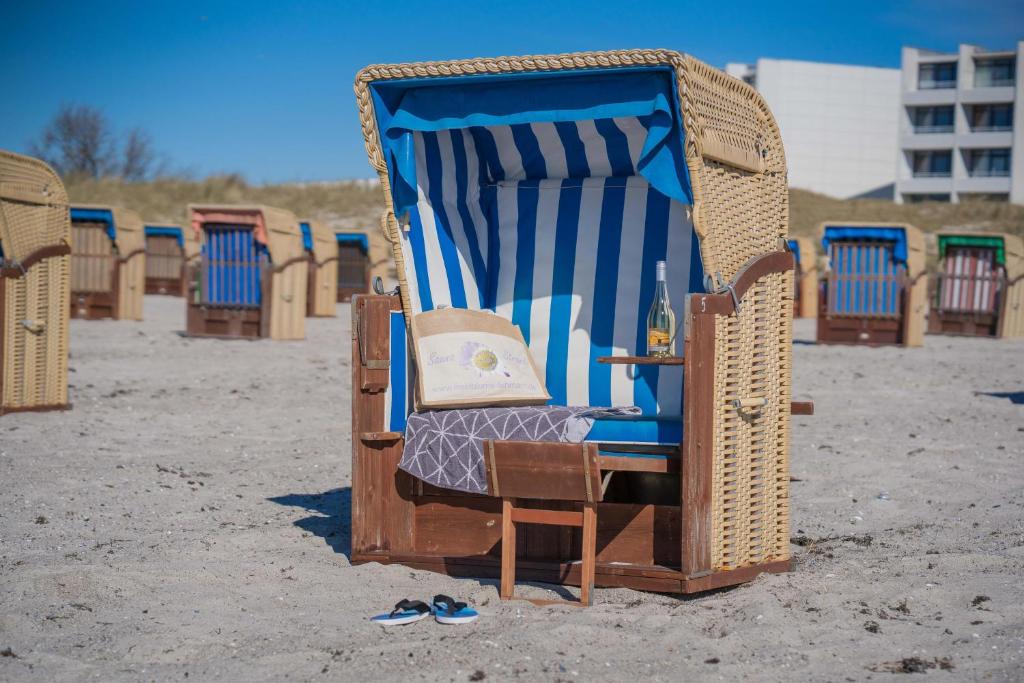 une pile de chaises de plage assises sur le sable dans l'établissement Inselblume 24 - Exklusive Ferienwohnung in der Strandburg, à Burgtiefe auf Fehmarn 