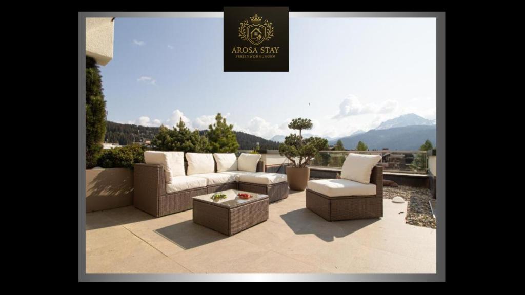 a patio with a couch and chairs and a table at Galerie Obersee 3E by Arosa Stay in Arosa