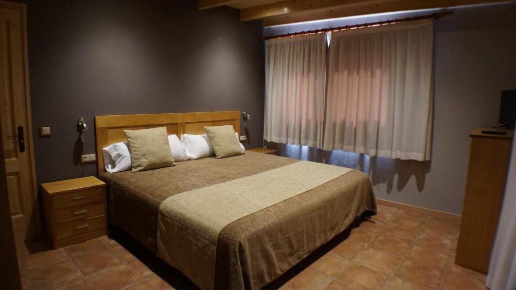 a bedroom with a large bed and a window at Can Barnosell - Els Masos d'en Coll in Llaviá
