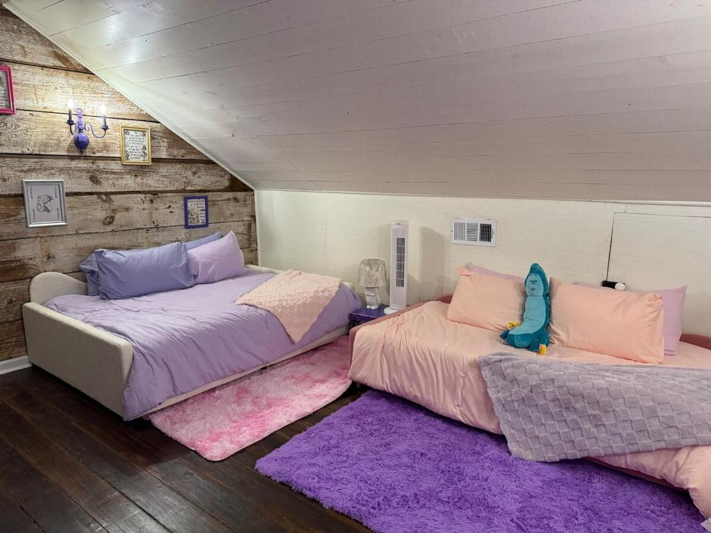 two beds in a room with purple and pink rugs at Alice by Ravens Keep in Jackson