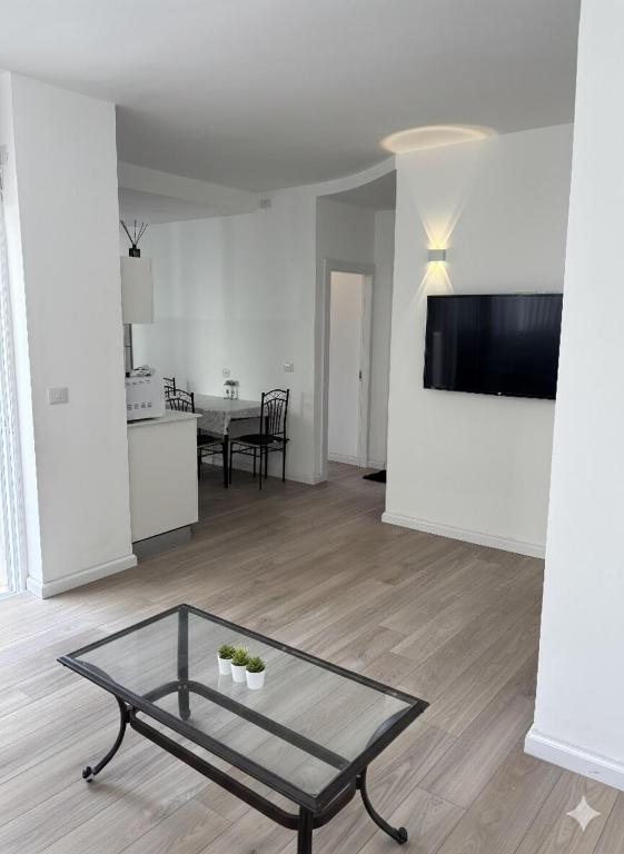 a living room with a glass table on a wooden floor at Ussishkin Penthouse in Netanya