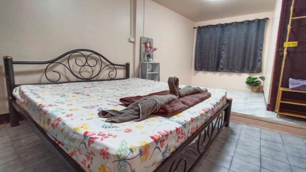 a bed in a bedroom with a blanket on it at Rhythm of life guesthouse 56 in Bangkok