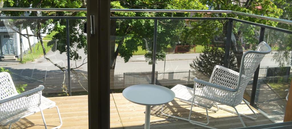 een veranda met drie stoelen en een tafel op een terras bij Aisa 39 Külaliskorter in Pärnu