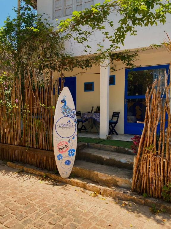 a surfboard leaning against a fence in front of a house at Casinha Blue Pipa in Pipa
