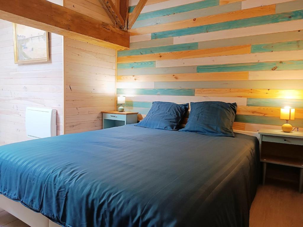 a bedroom with a blue bed with a wooden wall at Appartement, centre ville, 2 chambres, 6 pers in Loudun