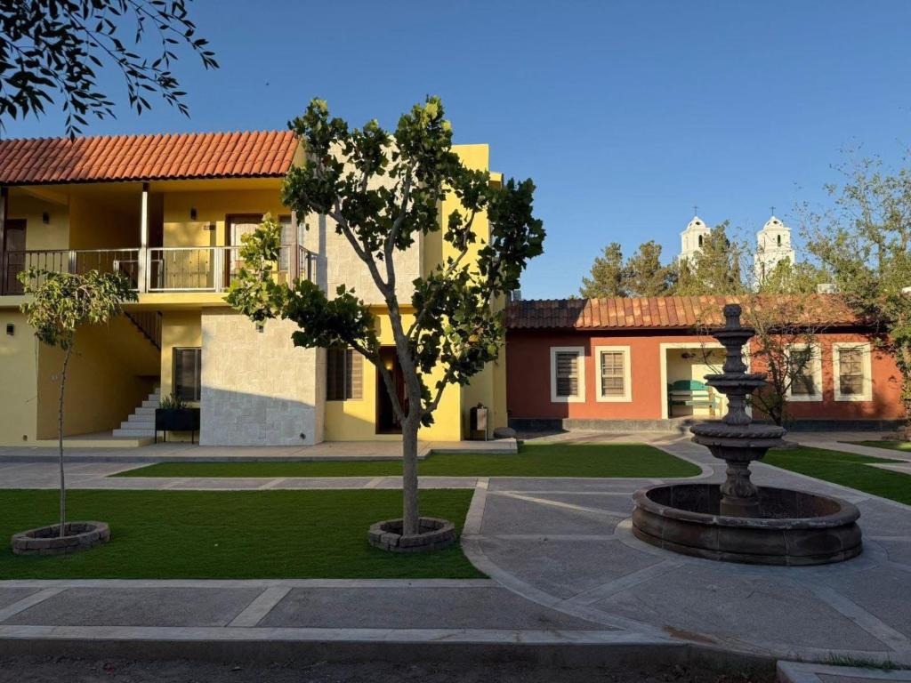 a courtyard with a tree in front of a building at Posada de Amparo in Casas Grandes