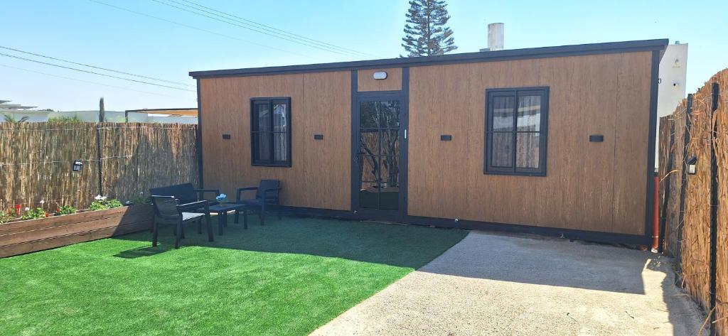 a small shed with a table and chairs in a yard at הבקתות של מאי 