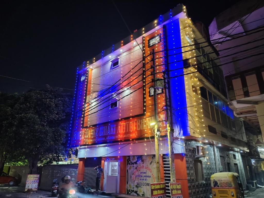 un bâtiment avec des lumières bleues et rouges sur lui dans l'établissement Shree Bankey Bihari Atithi Bhawan, à Mathura