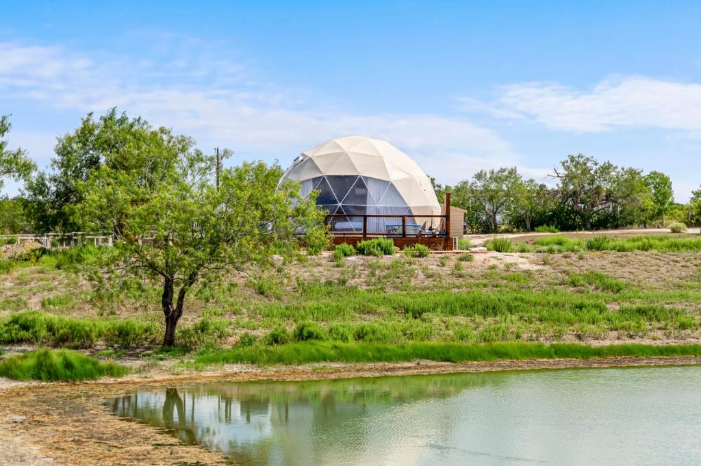 a dome house on a hill next to a river at Luxury Glamping Dome on Texas Farm in San Marcos