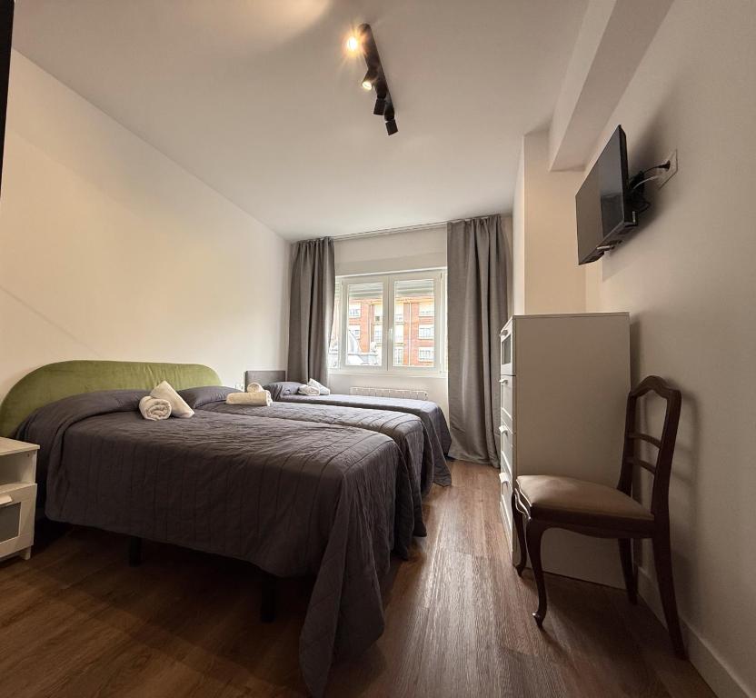 a bedroom with two beds and a chair in it at Abastos in Santoña