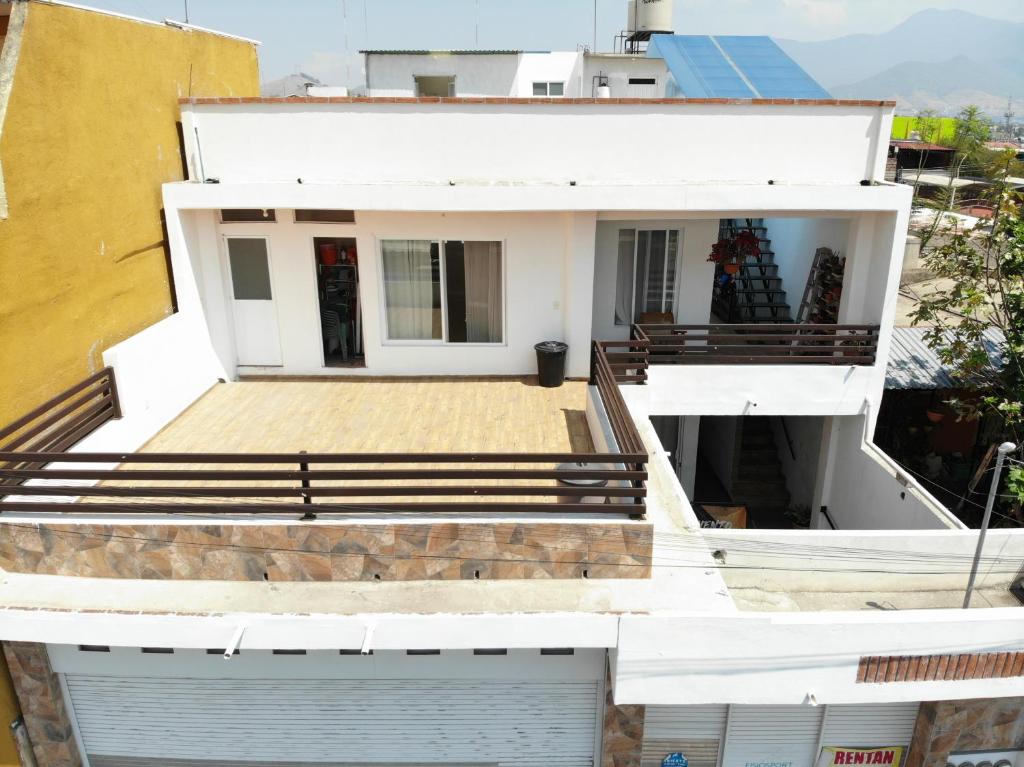 a white house with a porch and stairs at Casa Ba-Al, Bonitos Departamentos para 2 a 8 personas a 5 min del centro de Oaxaca in Oaxaca City