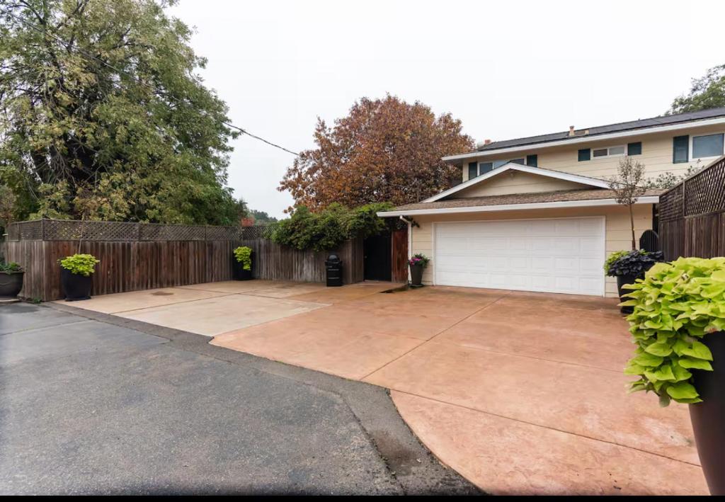 a backyard with a fence and a driveway at Sac Camp Delta Garden Retreat in Sacramento