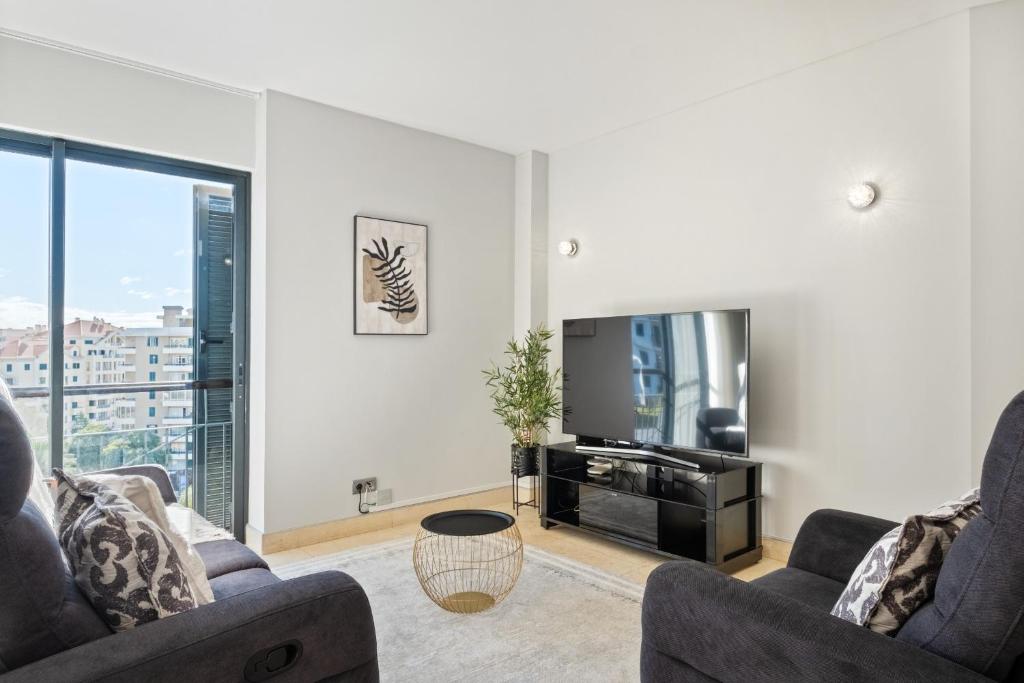 a living room with two couches and a flat screen tv at Fórum Glam 5B by Homie in Ilhéu do Gorgulho