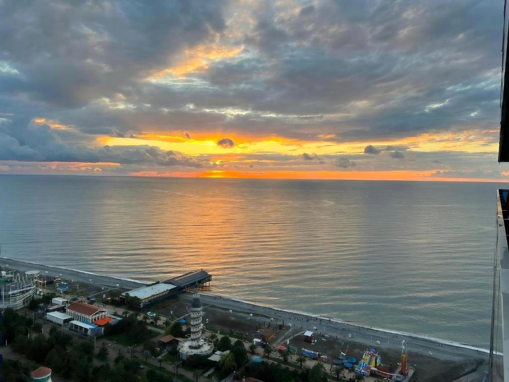 a sunset over a body of water with a city at ORBI CITY NEW APARTMENTS Official BATUMI in Batumi