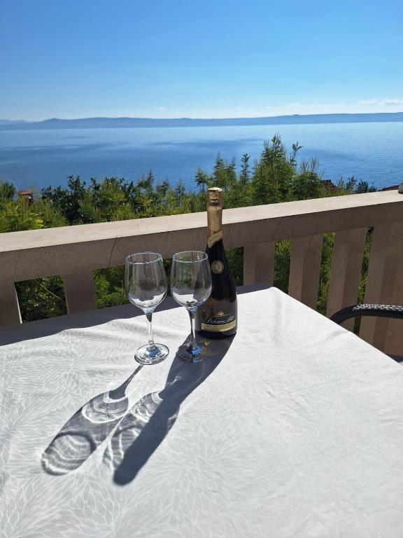 a bottle of wine and two wine glasses on a table at Villa Albatros in Selca