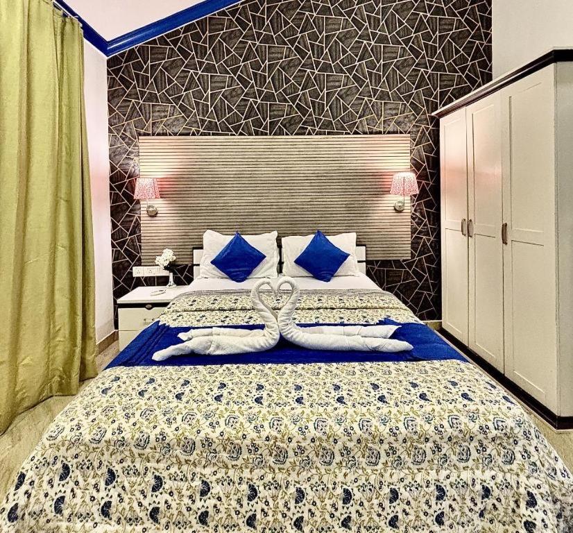 a bedroom with a large bed with blue pillows at Sky Bloom Villa in Nagoa-Bardez