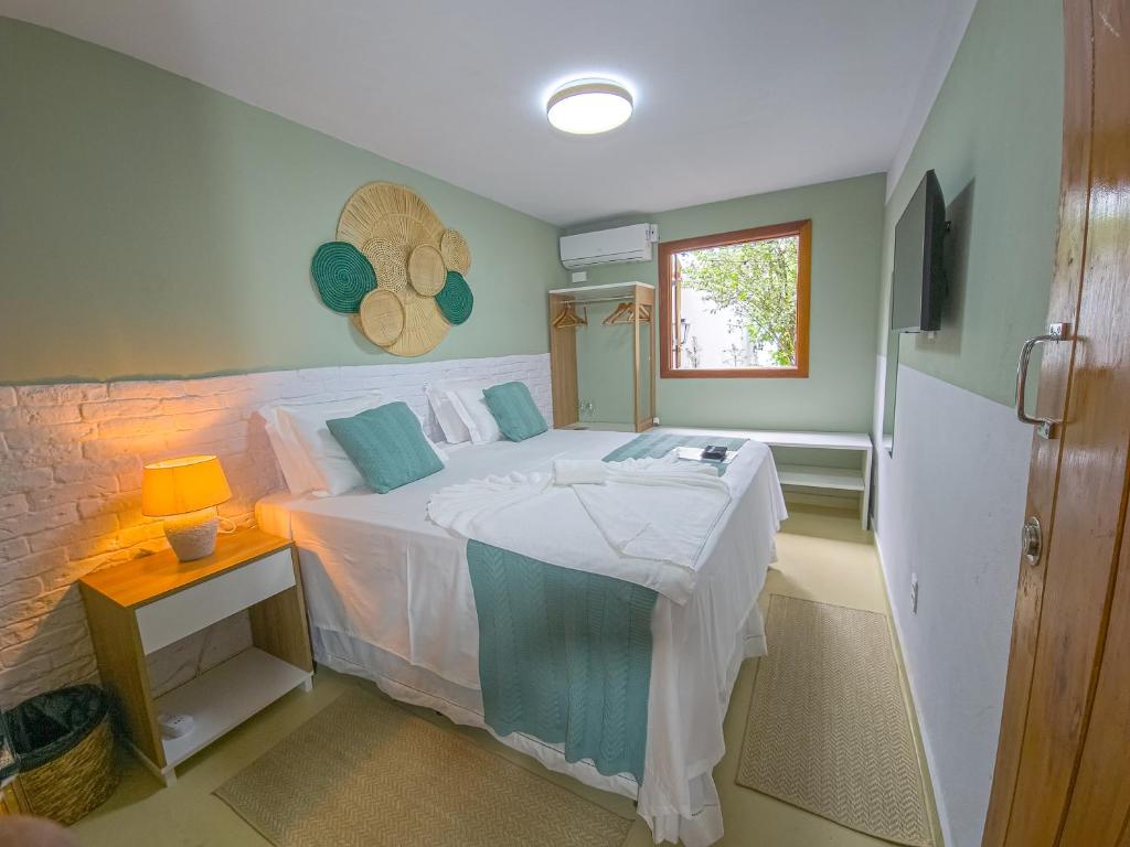 a bedroom with a white bed and a window at Pousada Céu da Chapadha in Mucugê