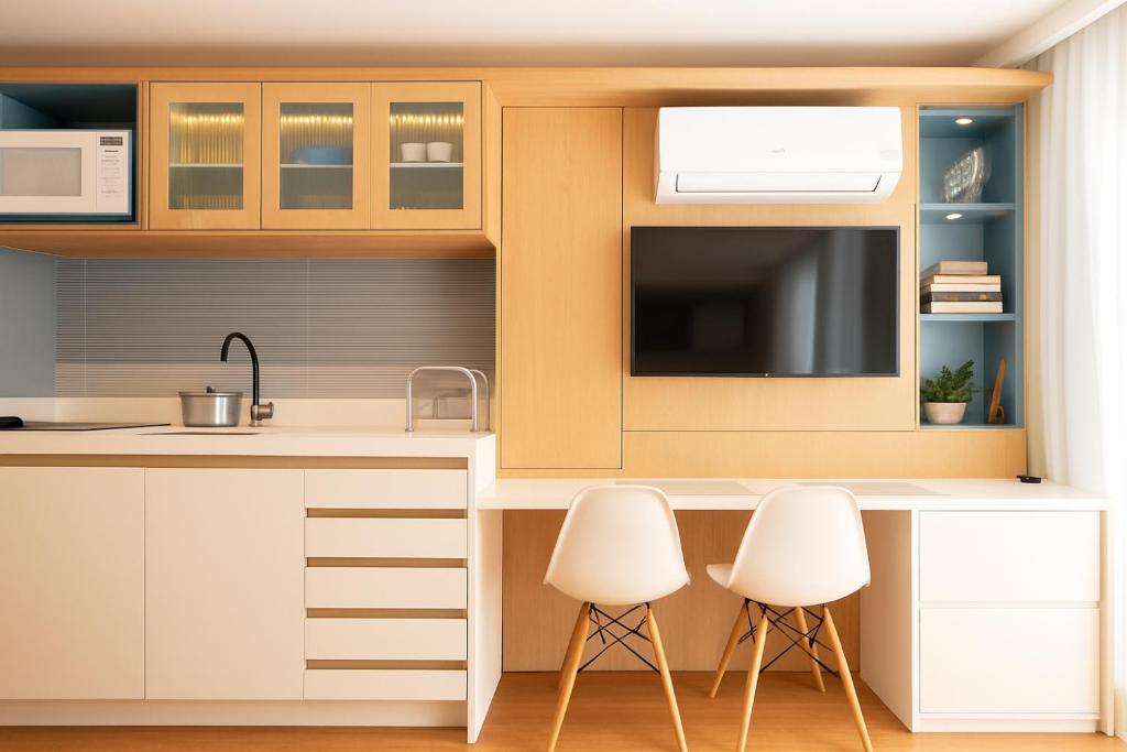 a kitchen with white cabinets and white chairs at 1306 - Luxuoso Studio BF - CWB Central - Com Garagem in Curitiba