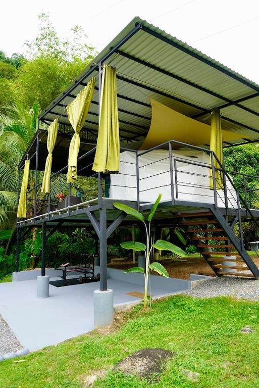 a building with yellow umbrellas and a table at Osaglamping in Palmar Norte