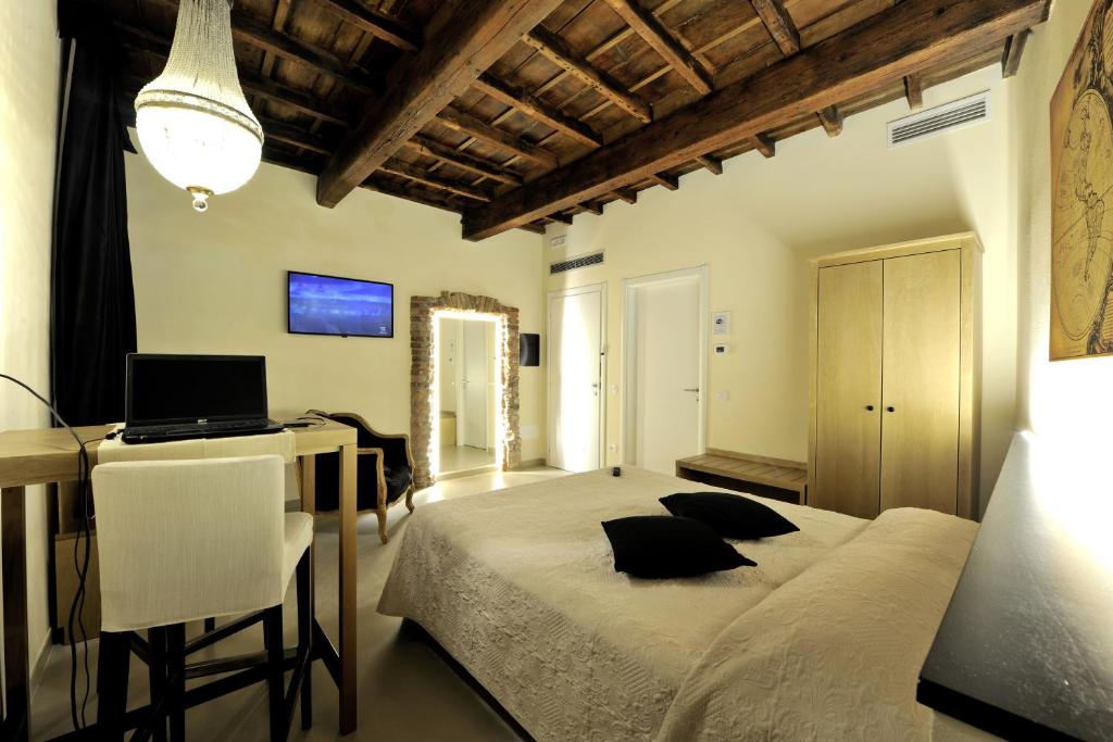 a bedroom with a bed and a desk with a laptop at Studio 27 in Ferrara