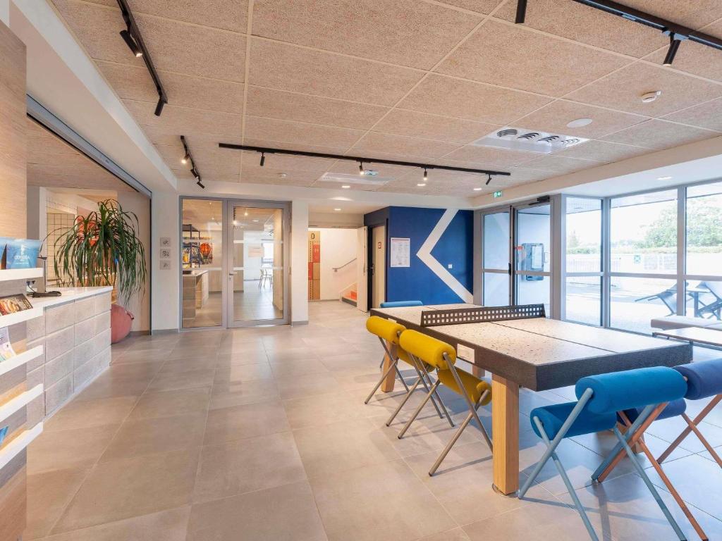 a dining room with a table and chairs at Hotel ibis Mont De Marsan in Mont-de-Marsan