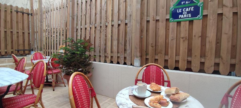 a patio with tables and chairs and a sign on a fence at PARIS AUTHENTIC HOUSE open space studio Métro 14 Hôpital Bicêtre, RER B Gentilly in Gentilly