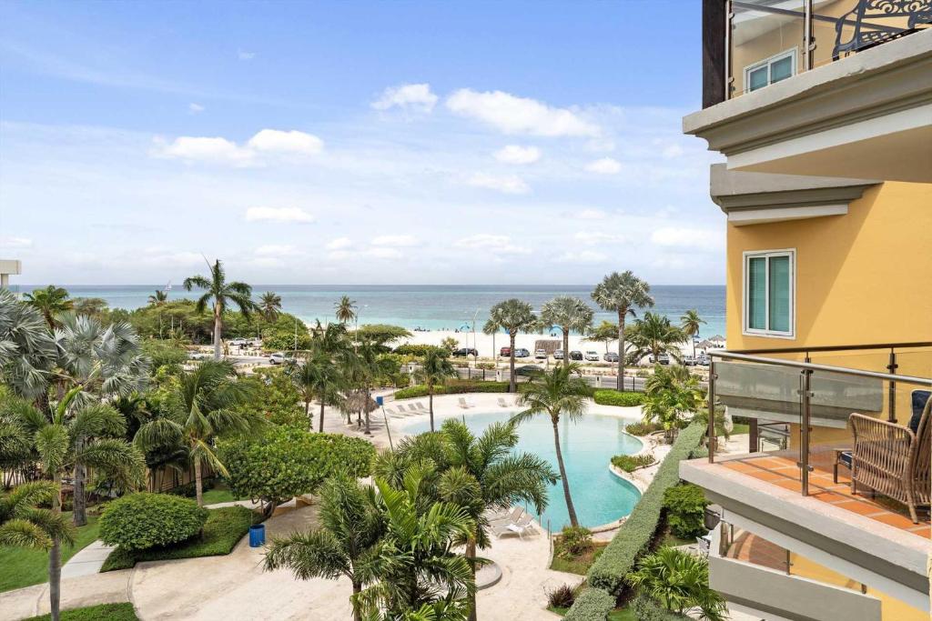 an aerial view of a resort with a swimming pool and the ocean at Beachfront - Best View 2BR condo - E422-2 in Palm-Eagle Beach
