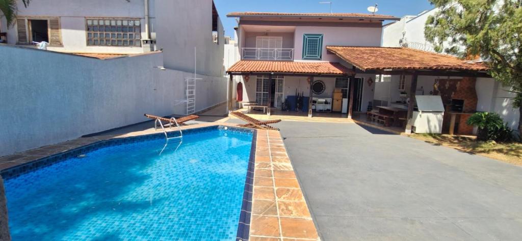 a swimming pool in front of a house at Casa da Rosa in Goiânia