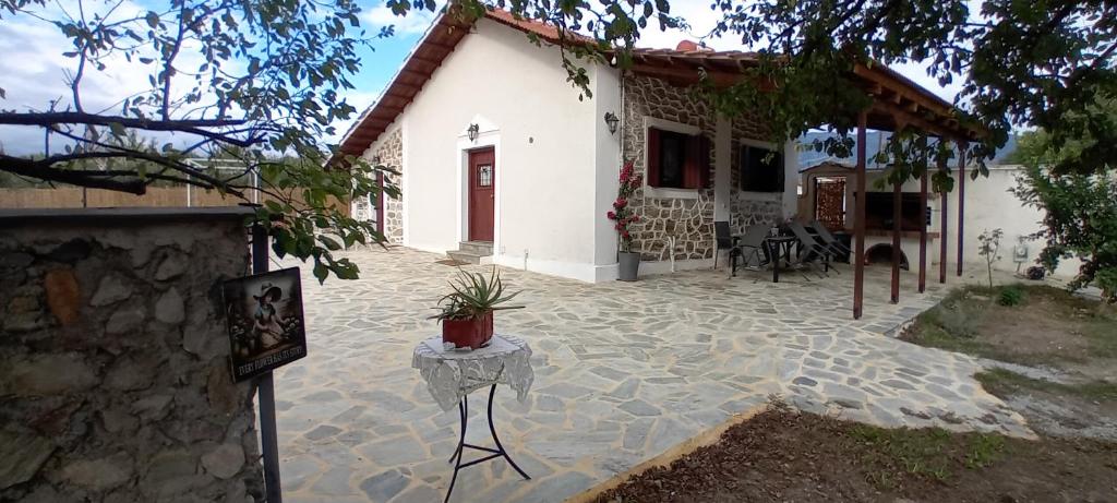 a stone patio in front of a white house at Aggelos Gardenhouse of Volos in Volos