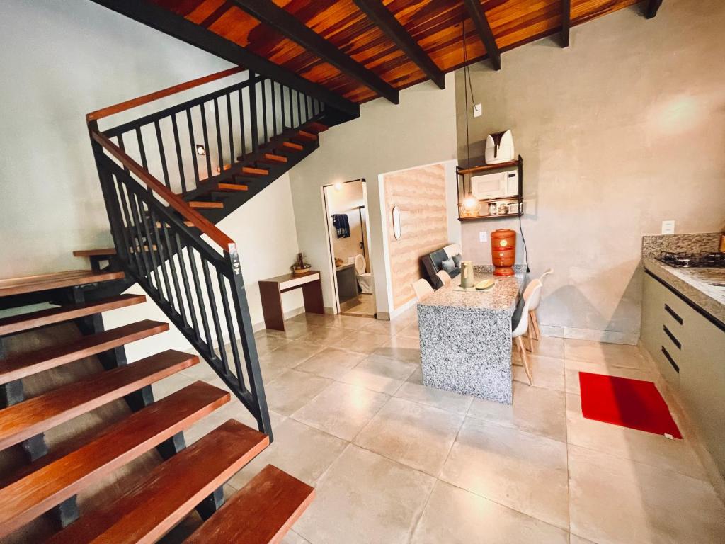 a kitchen with a staircase and a living room at Claruá Chalés - LOFT BARU- Lofts românticos em Cavalcante- 5m do centro in Cavalcante